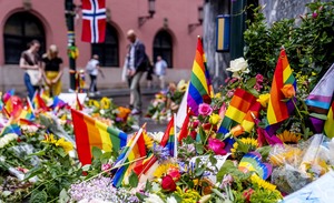 Bilde av store mengder blomster og regnbueflagg på gaten utenfor puben.