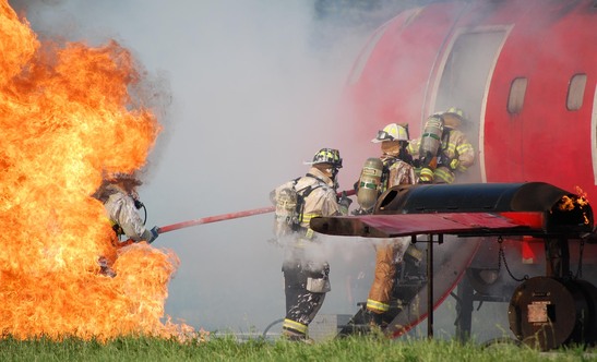 Brannfolk og røykdykkere på vei inn i et brennende fly.