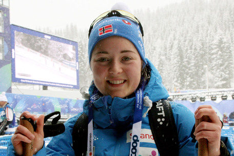 Vilde Nilsen støtter seg til skistaver og smiler
