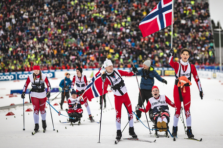 Team Pølsa går i mål i Granåsen med flagg
