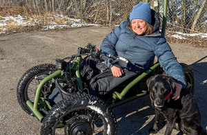 Heidi Rahm på firehjuls aktivitetssykkel med servicehund