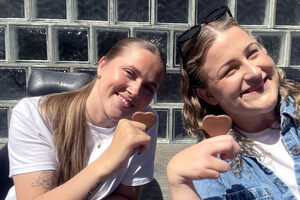 Hannah Lunden og Amalie Rakkestad smiler og holder hvert sitt melkesjokoladehjerte