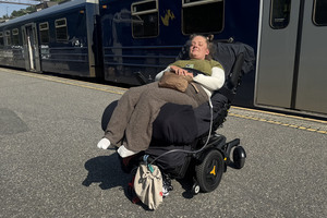 Marianne Knudsen i el-rullestol på togperrong, tog i bakgrunnen
