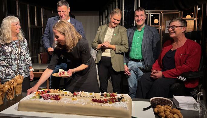 Astrid Aas Hansen deler ut kakestykker fra stor marsipankake