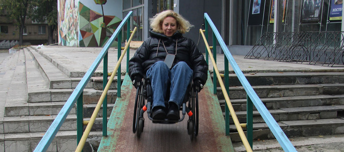 Olena Akopian i rullestol på vei ned rampe
