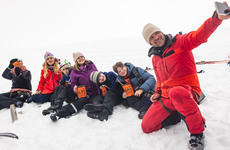 Øystein tar selfie sammen med seks funksjonshemmede ungdommer som har matpause på en bre.