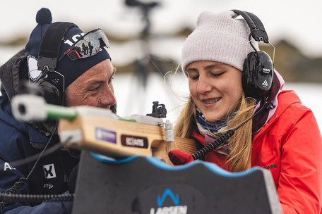 Jente på liggende standplass på skiskyting får hjelp av instruktør