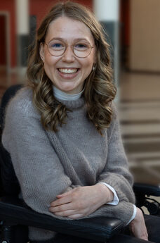 Marie Flaatten i elektrisk rullestol smiler til kameraet