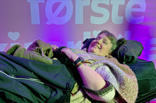 Marianne Knudsen foran fotovegg for Min første kjærlighet