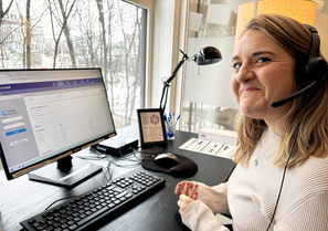 Kvinne med telefonheadset foran PC