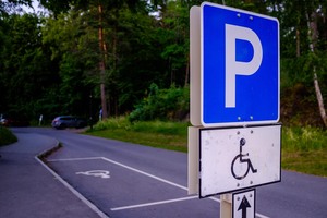Bilde av en parkeringsplass merket med HC-skilt.