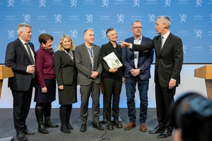 Bjørnar Skjæran og Jens Stoltenberg på hver sin side av fem medlemmer av kommunekommisjonen.