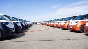 To rekker av parkerte el-kassebiler, henholdsvis mørkeblå og oransje