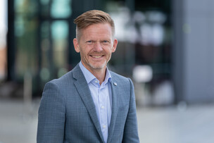 Tage Pettersen utenfor bygg med mye glass i fasaden