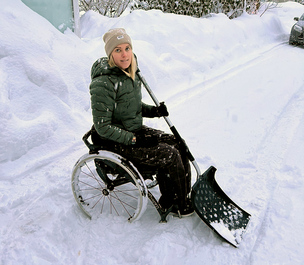 Cecilie Klungtveit i rullestol med snømåke i innkjørselen sin