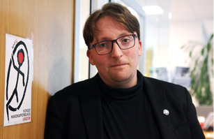 Mikkel Sibe ved dør med NHFU-logo