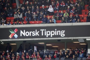 Bilde av publikum på tribunen, der en lystavle viser Norsk Tippings logo.