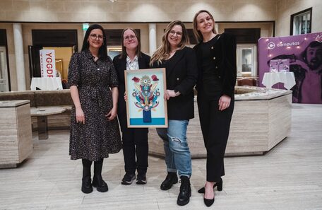 Fire kvinner holder Brukeropplevelsesprisen, i form av et kunstverk
