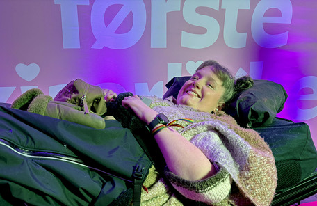 Marianne Knudsen foran fotovegg for Min første kjærlighet