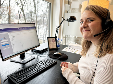Kvinne med telefonheadset foran PC