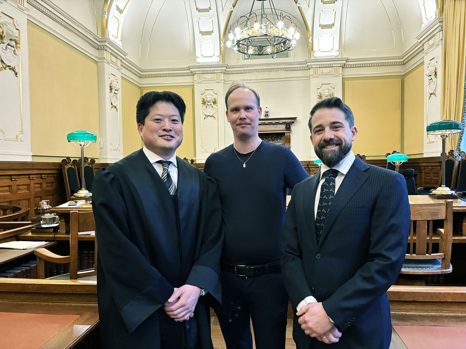 Frode Stenrud mellom to advokater i rettssal