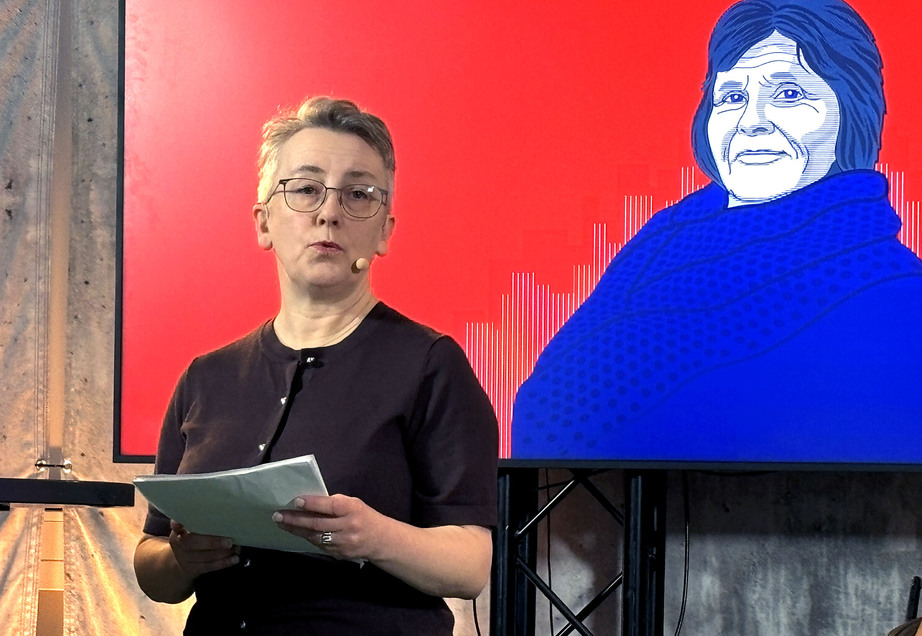 Rannveig Frøseth Sinkaberg holder foredrag foran tegning av Bente Skansgård