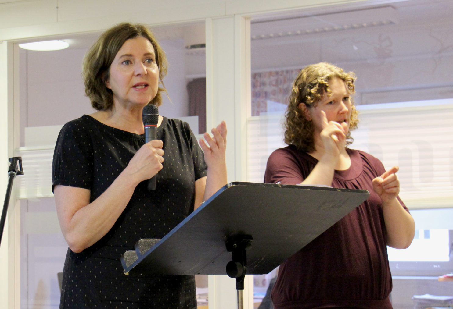 Hanne Bjurstrøm holder innlegg på frokostseminaret. Tegnspråktolk til høyre.