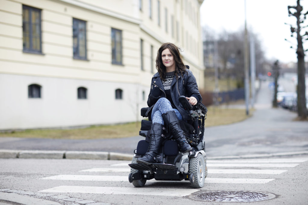 Ingrid Thunem krysser gate i elektrisk rullestol.