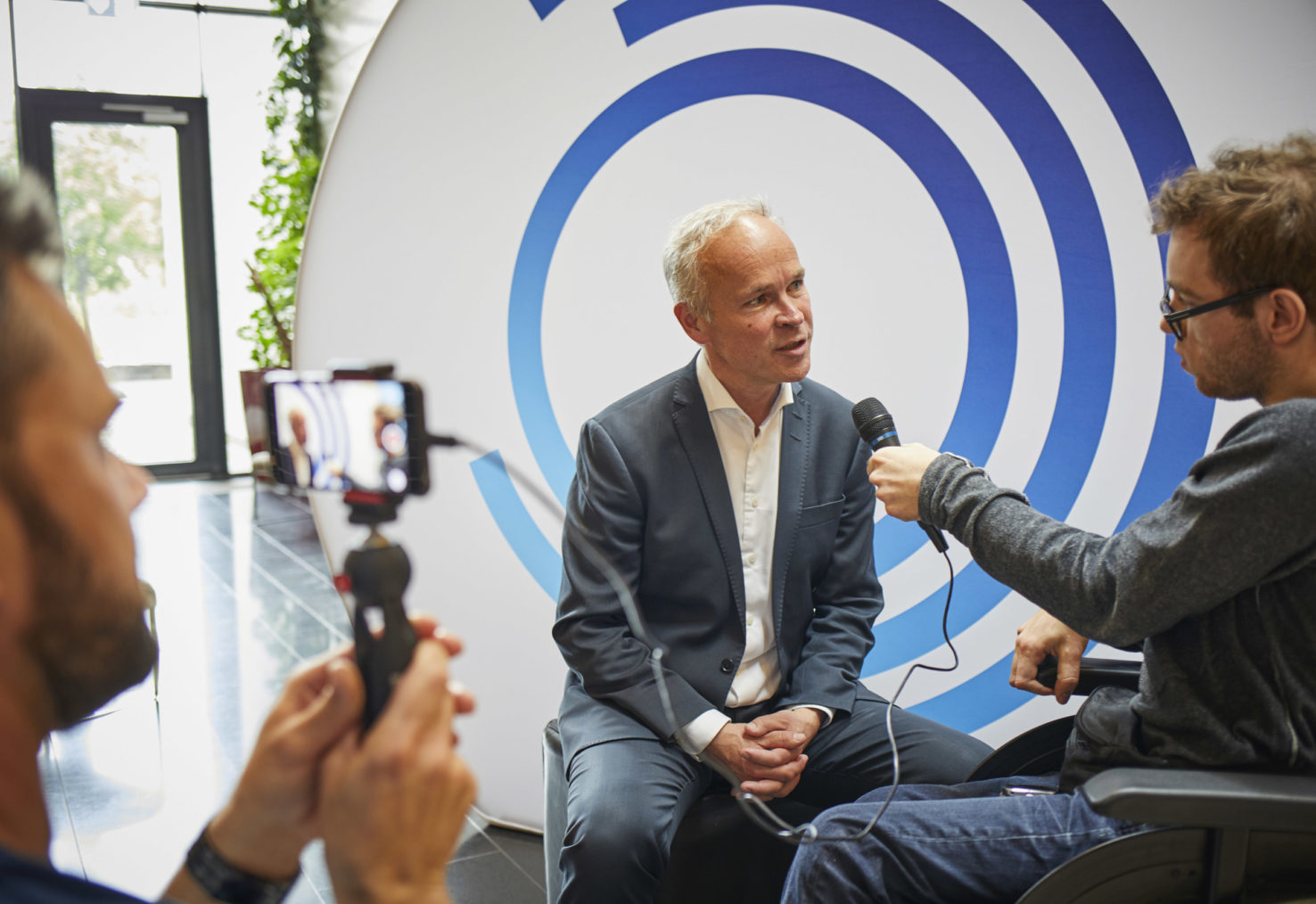 Jan Tore Sanner blir intervjuet foran NHF-logoen.