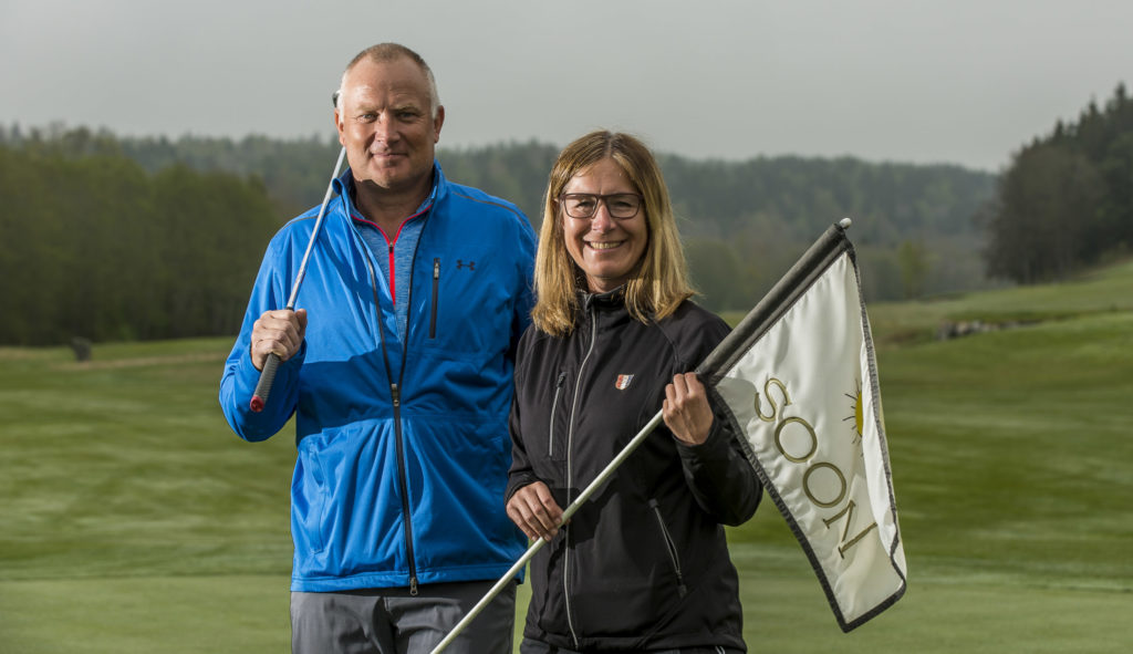 Per-Arne og Gøril poserer med golfflagg og kølle.