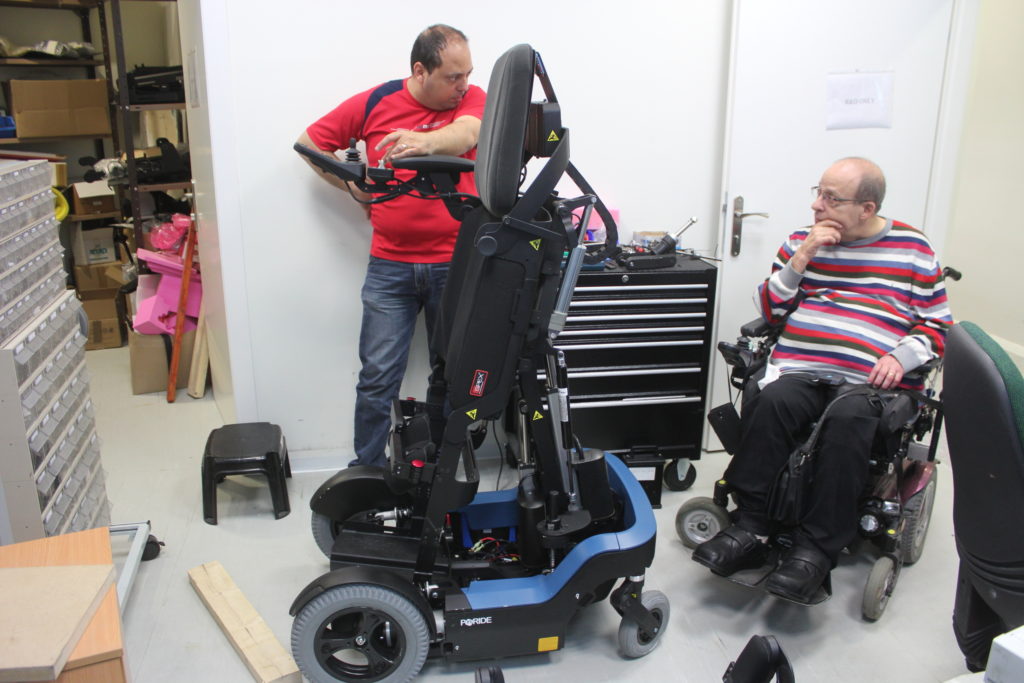 De to fotografert ved en rullestol-prototyp i bedrfitens lokaler.