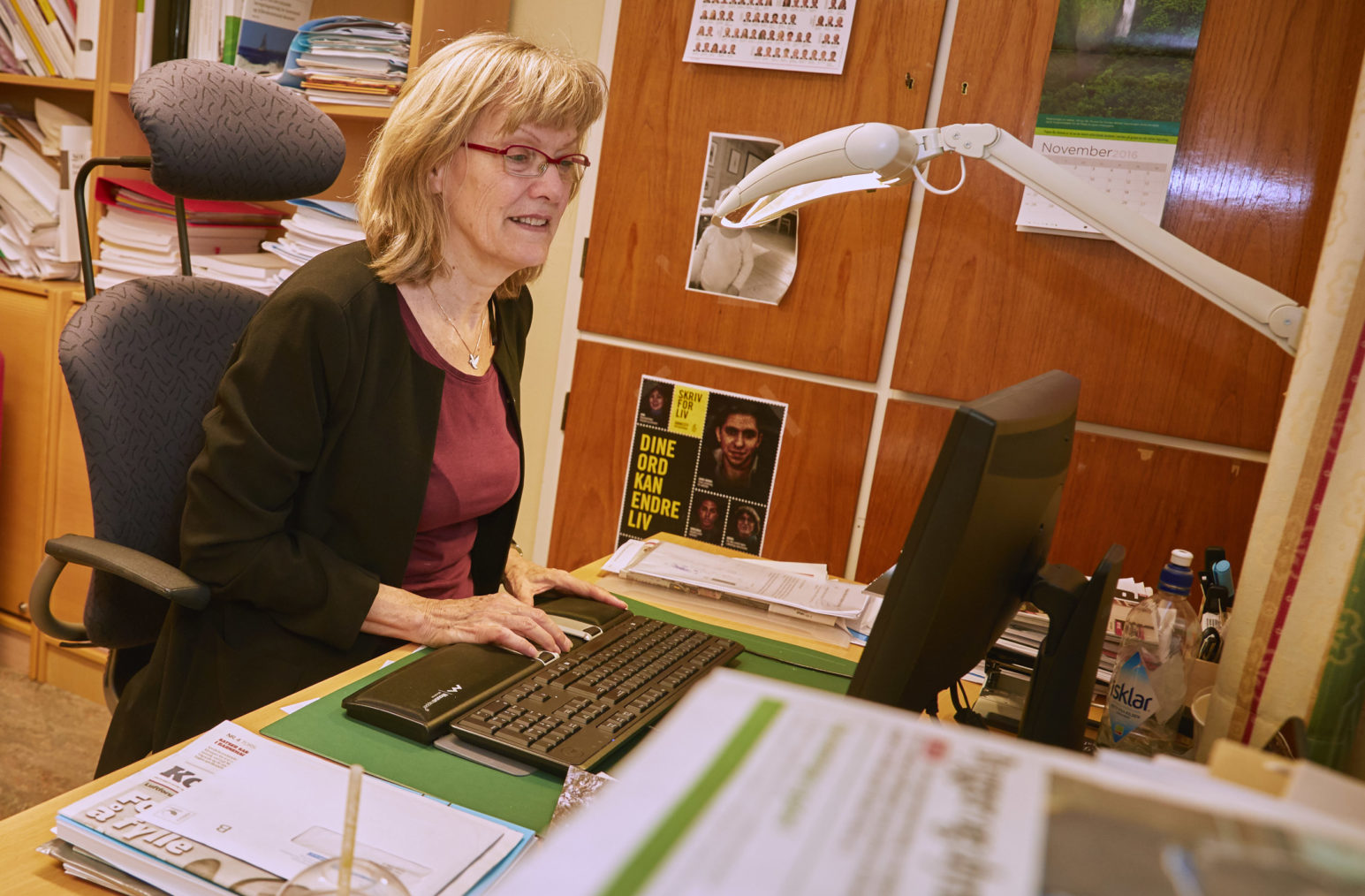 Bilde av Karin Andersen ved skrivebordet på kontoret i Stortinget.