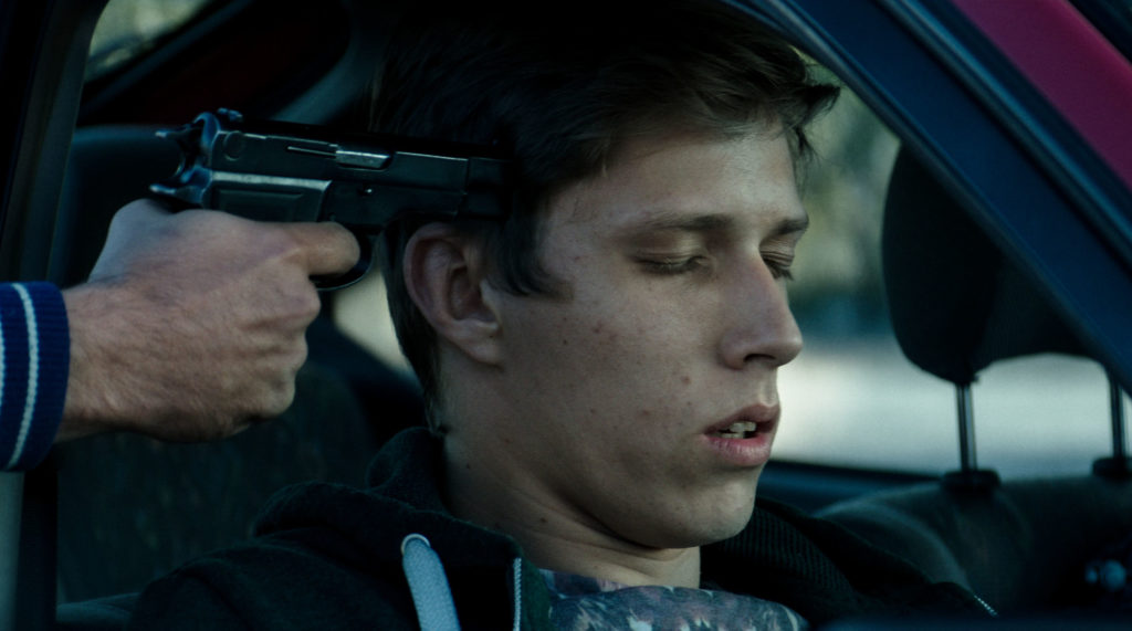 En av filmens hovedpersoner sitter i en bil og får en pistol mot tinningen.