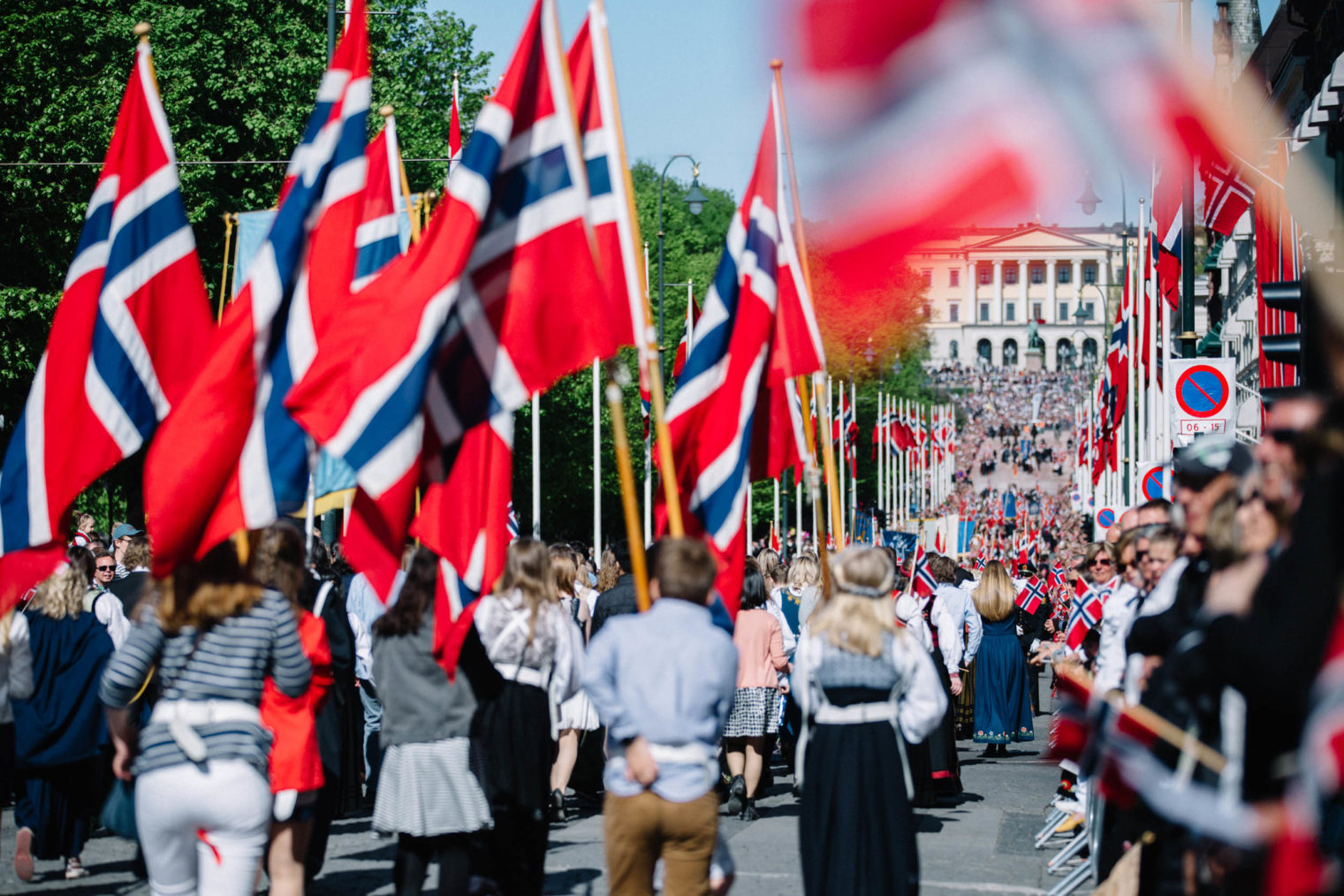 Bilde av 17. maitog på Karl Johans gate i Oslo, med slottet i bakgrunnen.