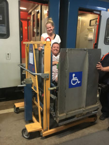 Bilde av Stine og assistent som prøver å komme om bord i et tog med en handikap-heis.