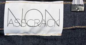 Nærbilde av merkelappen på jeansene: Non Ascrack