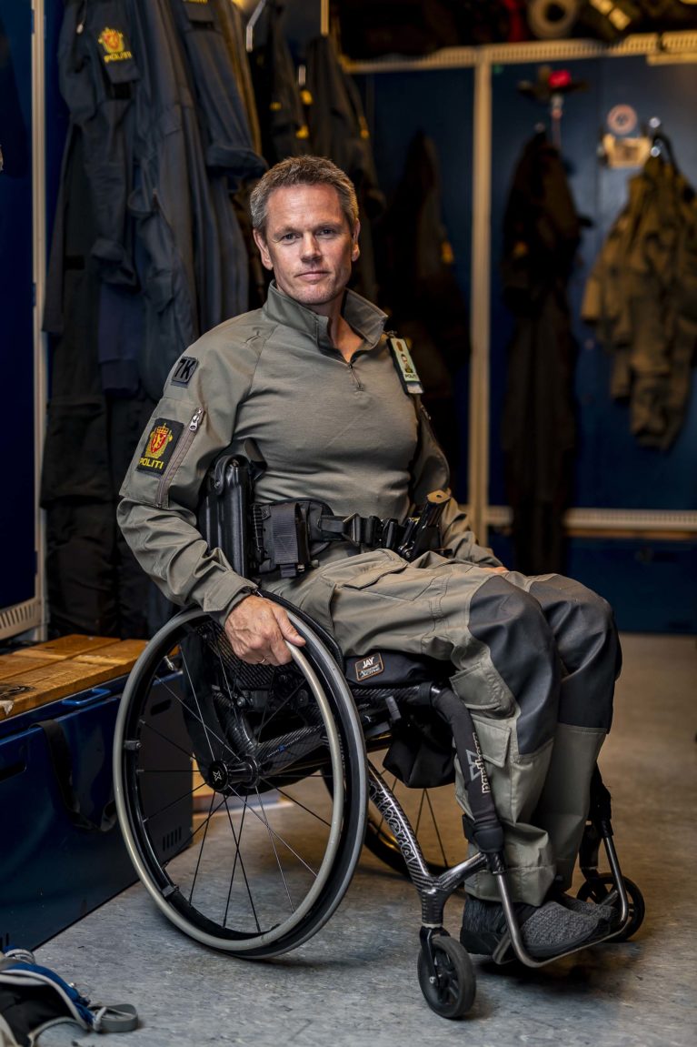 Trond hammer i rullestol og politiuniform.