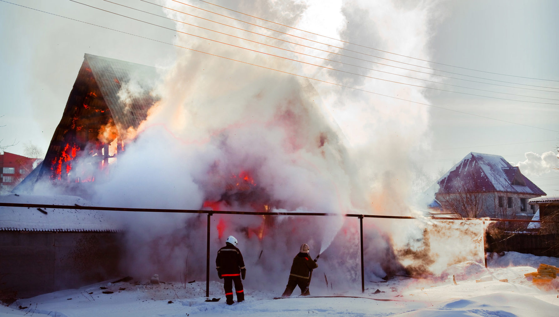 Bilde av brannmannskaper som slukker brennende bolighus.
