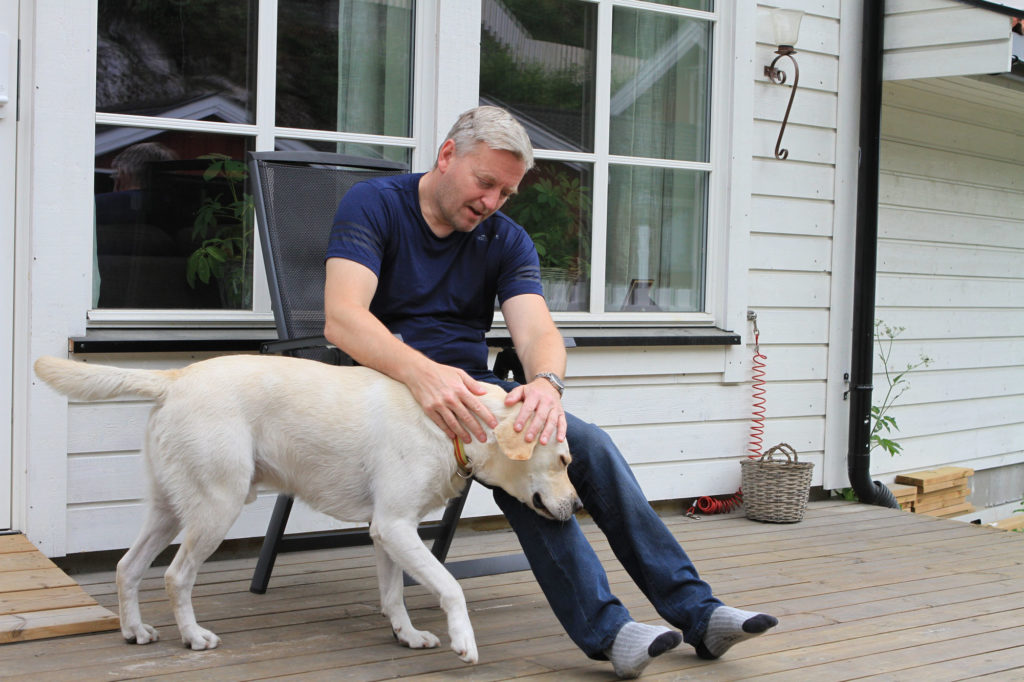 Kjetil og hunden sammen ute på terrassen.