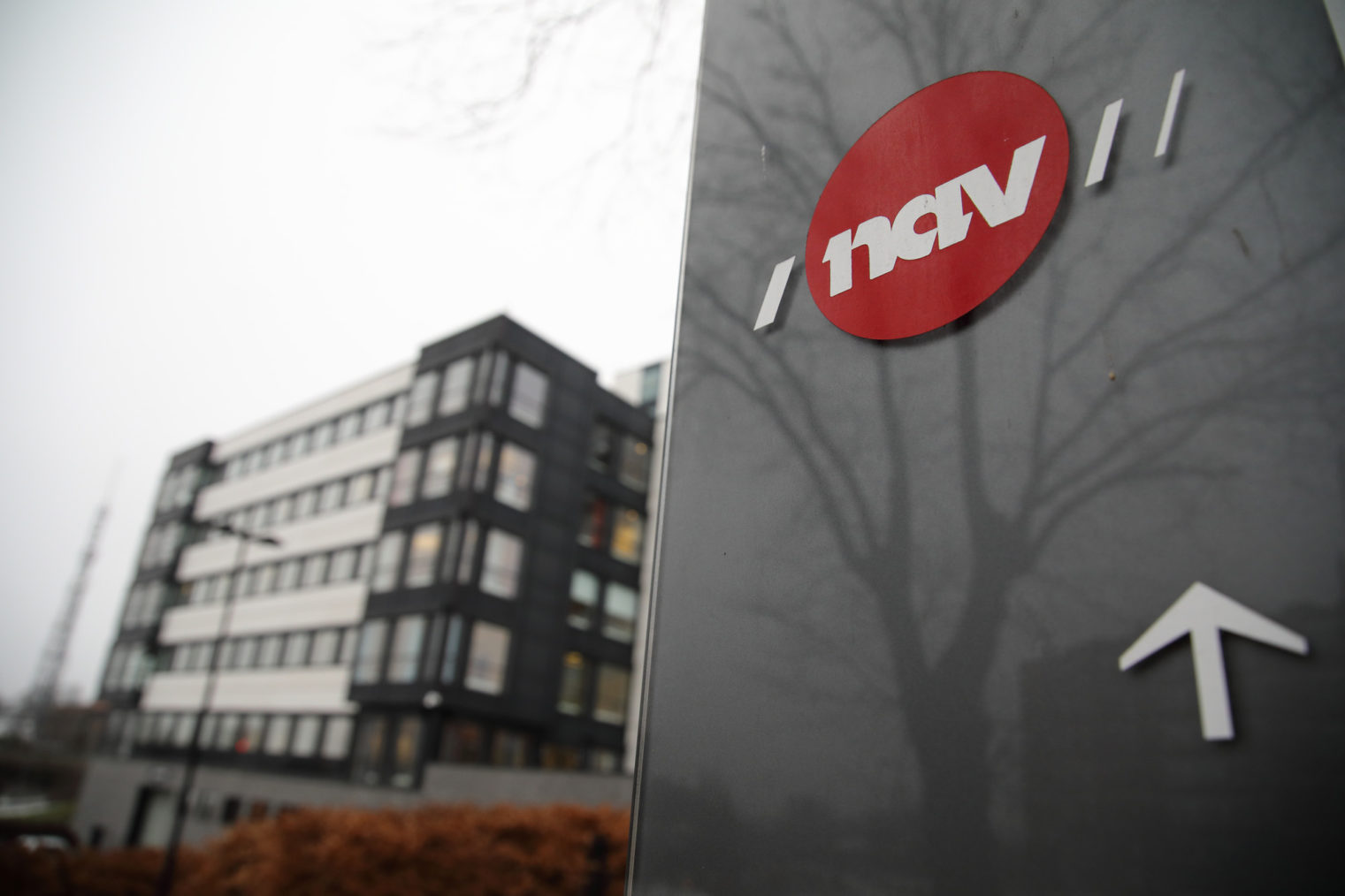 Bilde av bygningen der hjeløemiddelsentralen holder til, med Navs logo på et skilt i forgrunnen.