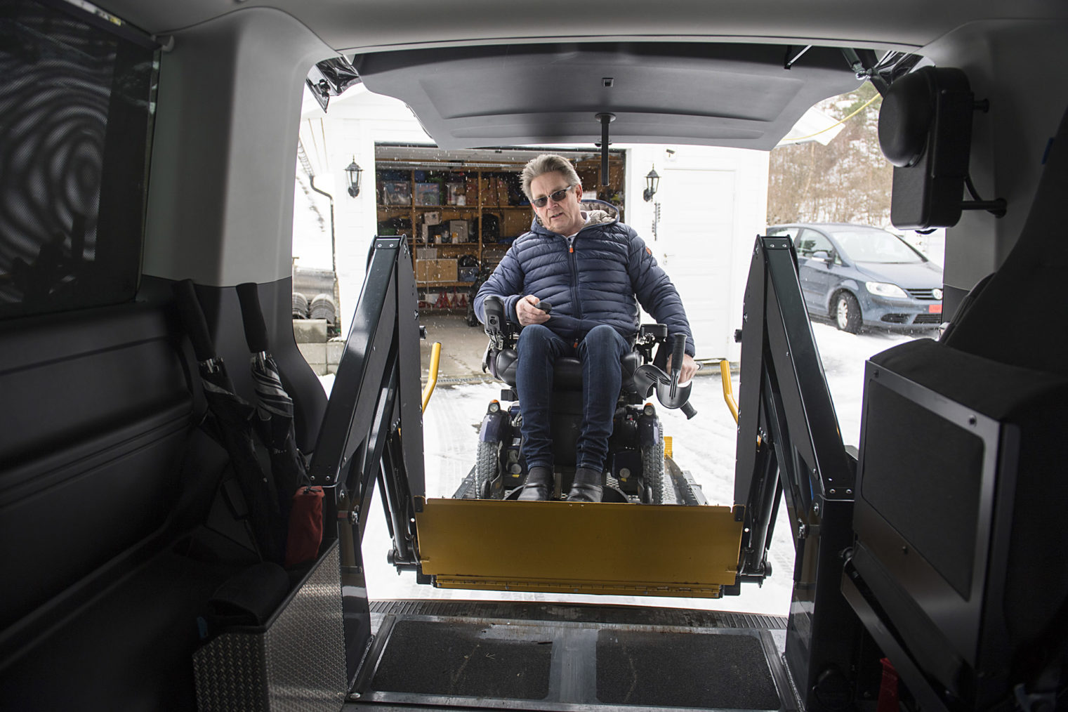 Hansen kjører med rullestol opp på rampa og inn i bilen.