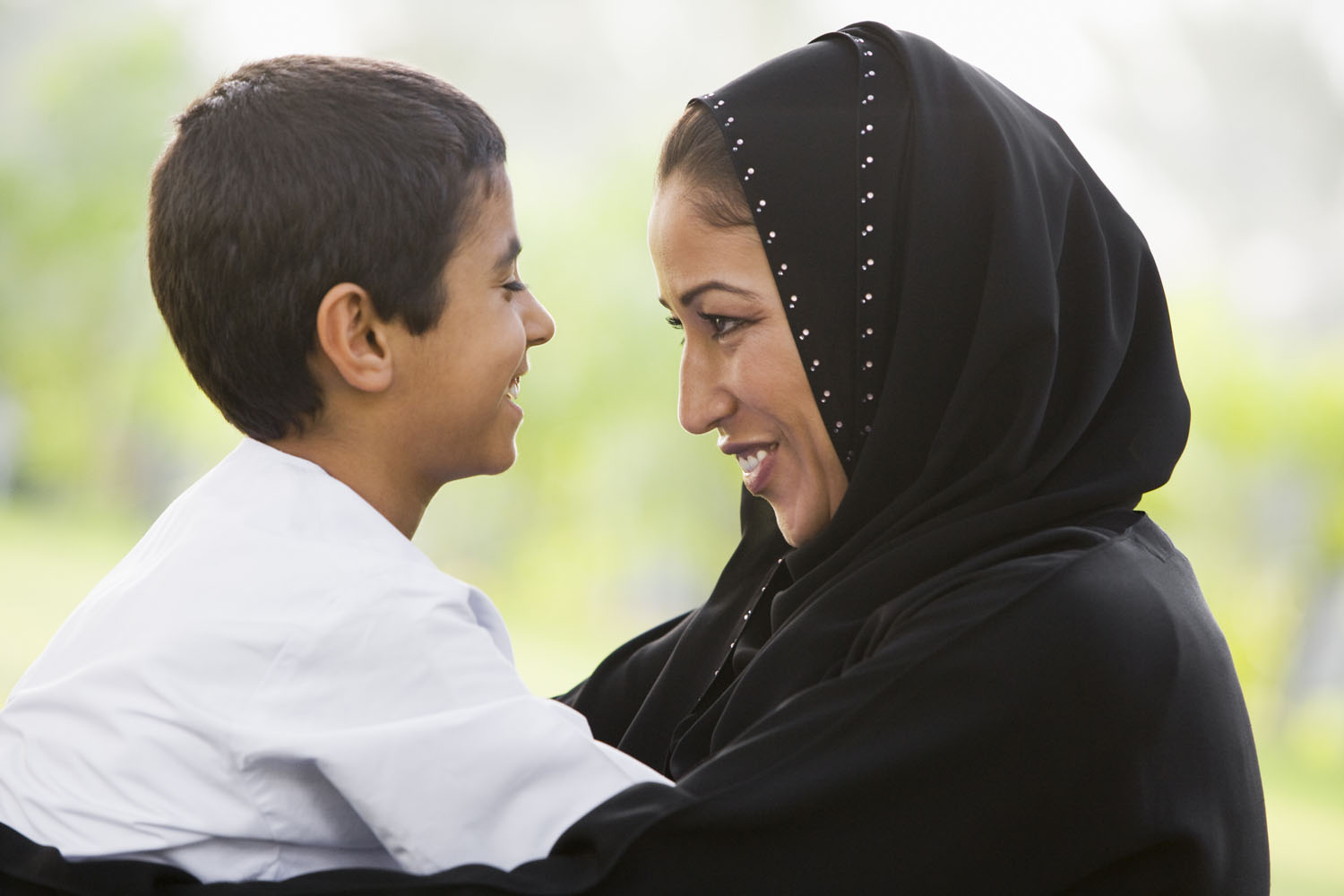 Mor fra Midtøsten og sønn ser på hverandre og smiler.