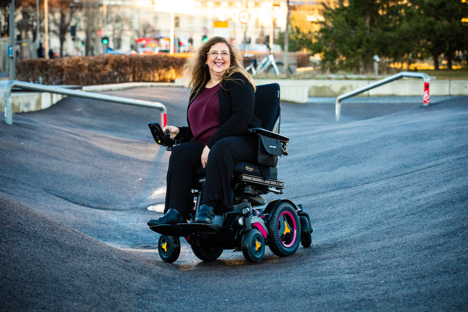 Kirsti Stenersen i elektrisk rullestol midt på en skatebane.