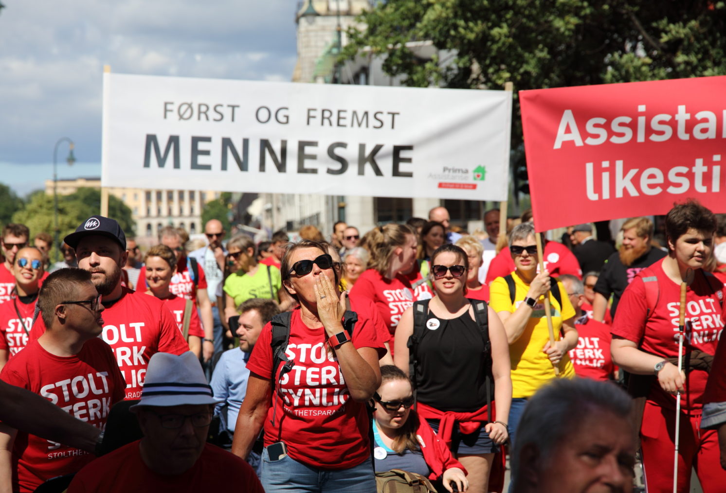 Bilde av mennesker i paraden på Karl Johan. Midt i bildet er et banner med teksten «Først og fremst menneske».