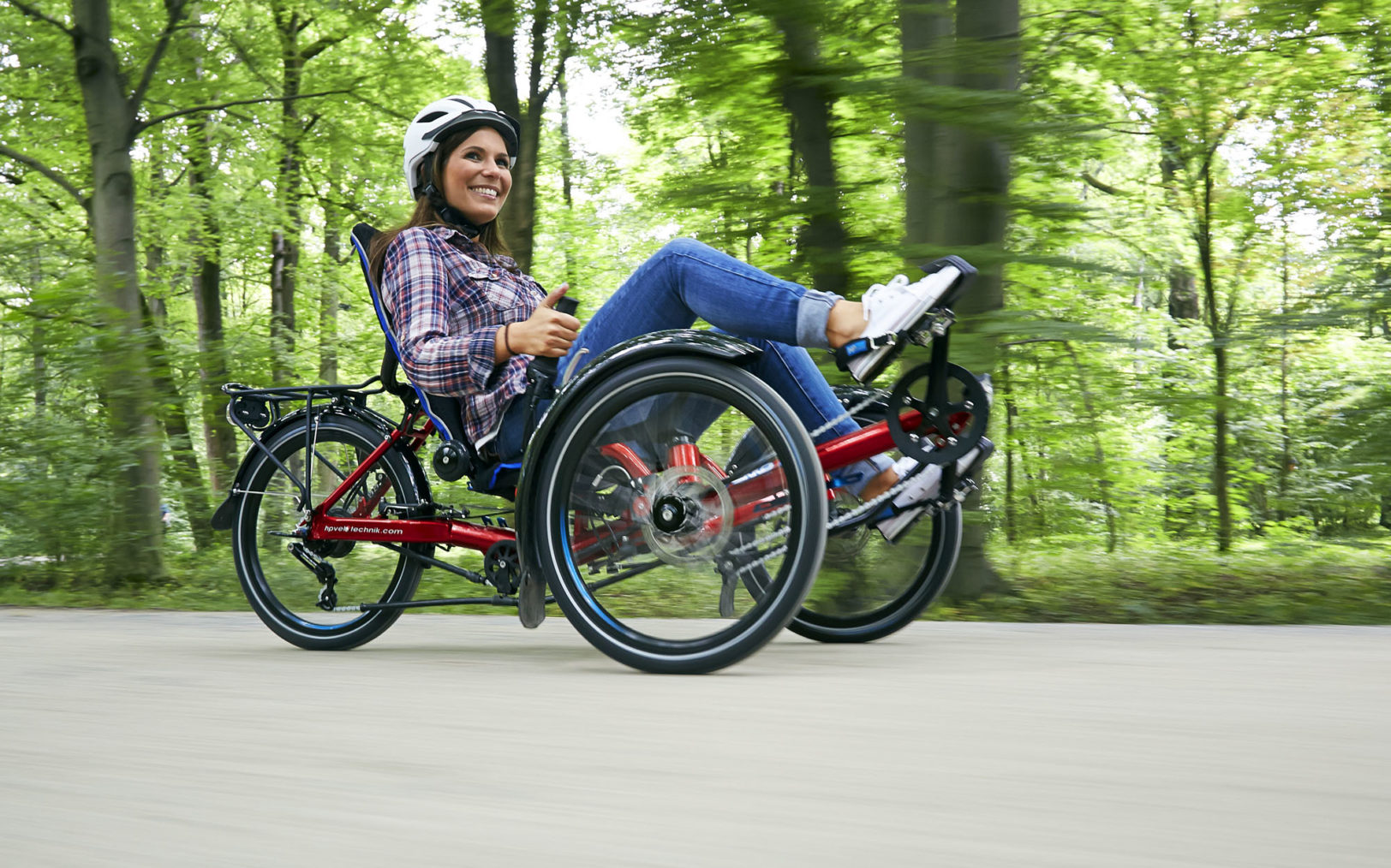 Kvinne kjører trehjuls liggesykkel.