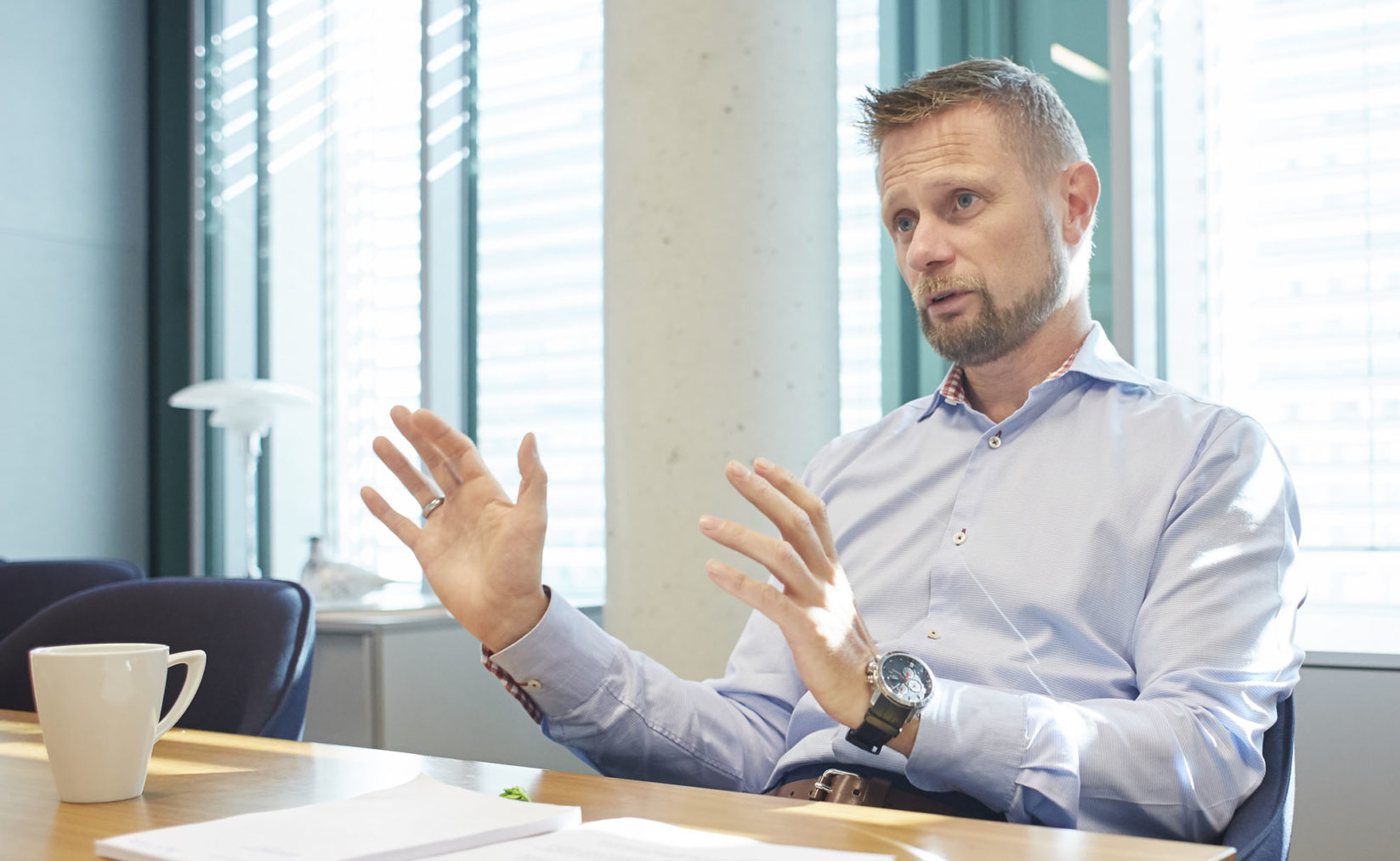 Bent Høie sitter ved et møtebord og gestikulerer med hendene.