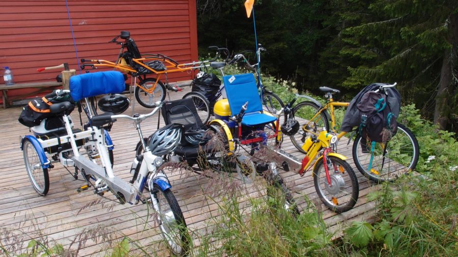 Bilde av parkerte handikapsykler utenfor en hytte.