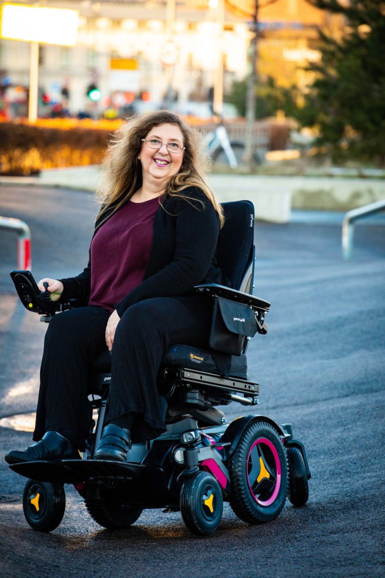 Kirsti Stenersen i elektrisk rullestol midt på en skatebane.