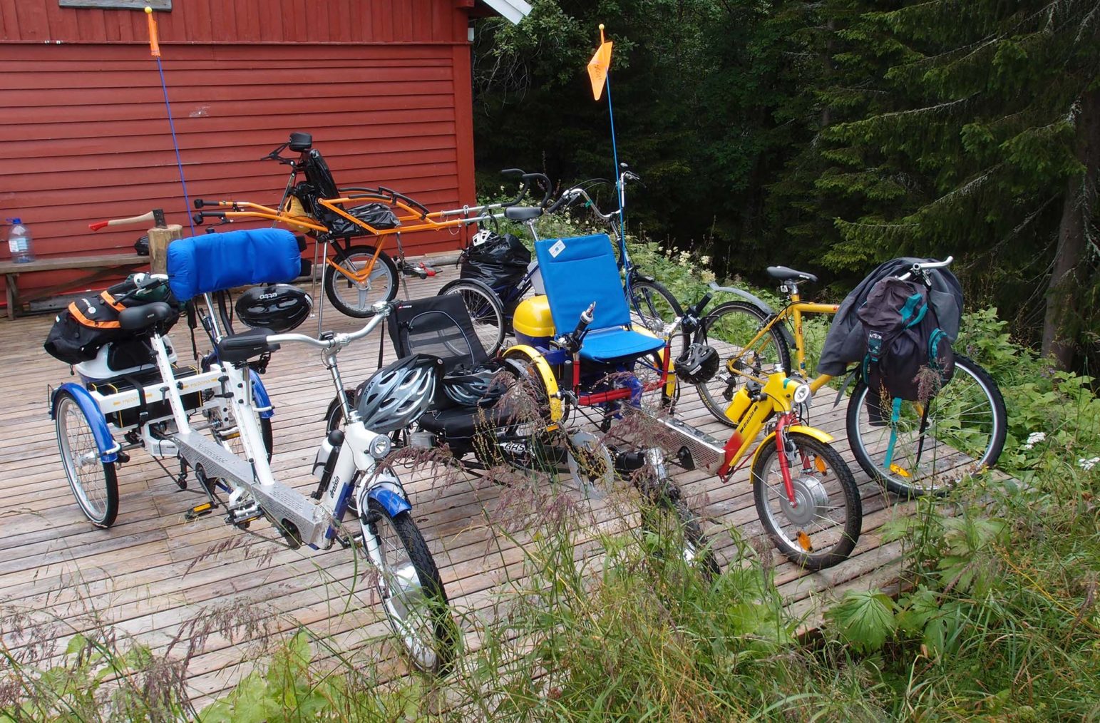 Bilde av flere parkerte sykler for funksjonshemmede utenfor en hytte.