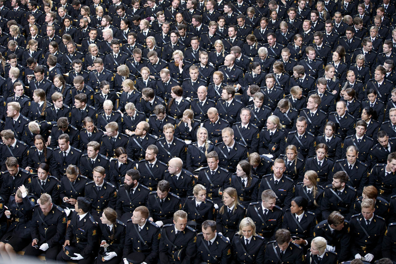 Sal full av politistudenter i uniform fotografert ovenfra.